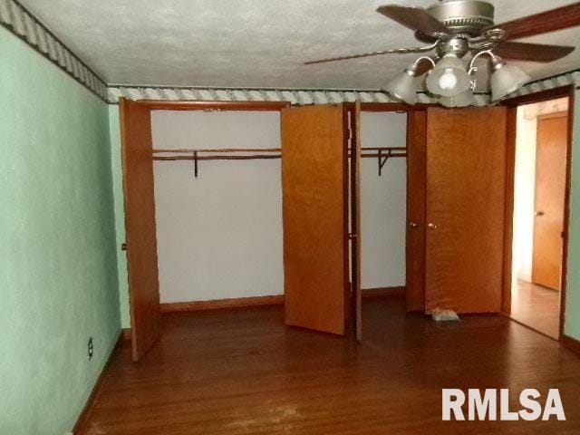 unfurnished bedroom featuring a textured ceiling, ceiling fan, wood finished floors, and baseboards