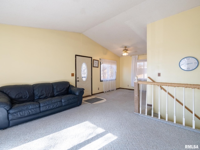 carpeted living room with lofted ceiling and baseboards