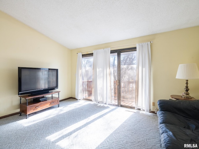 living room featuring lofted ceiling, a textured ceiling, baseboards, and carpet flooring