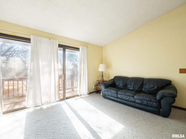 carpeted living area with lofted ceiling, a textured ceiling, and baseboards