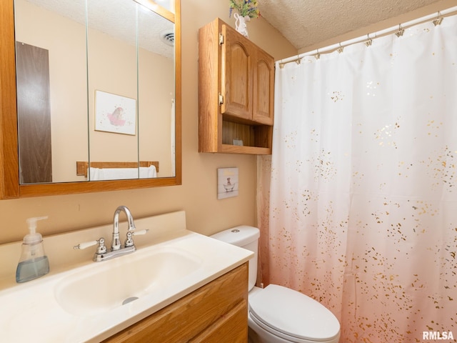 bathroom featuring a textured ceiling, curtained shower, vanity, and toilet