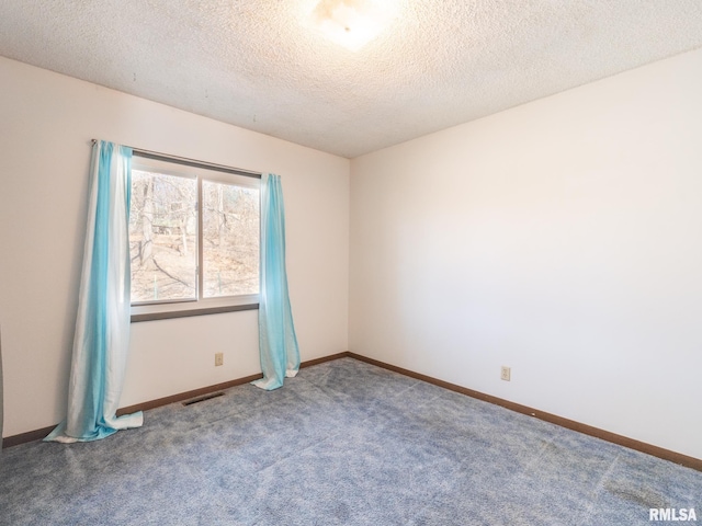 empty room with carpet floors, baseboards, visible vents, and a textured ceiling