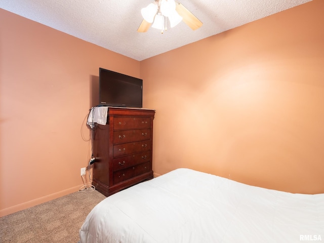 carpeted bedroom with a textured ceiling, a ceiling fan, and baseboards