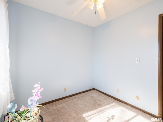 spare room with carpet flooring, a ceiling fan, and baseboards