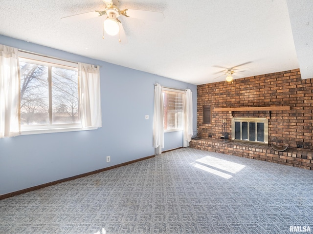 unfurnished living room with a brick fireplace, carpet, ceiling fan, and a textured ceiling