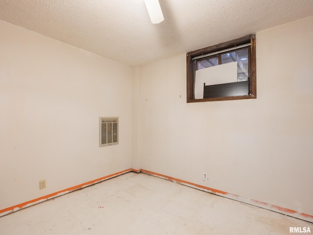 spare room featuring baseboards, concrete floors, visible vents, and a textured ceiling