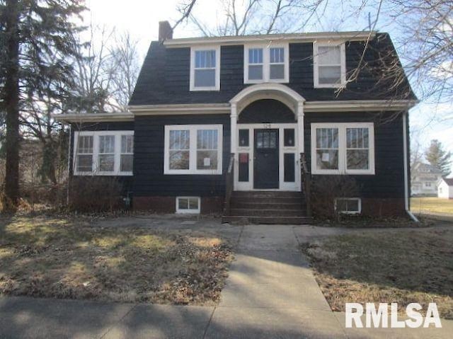 view of front of property with entry steps and a chimney