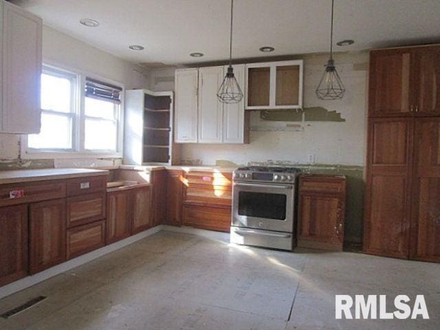 kitchen with stainless steel gas stove, visible vents, brown cabinets, hanging light fixtures, and open shelves