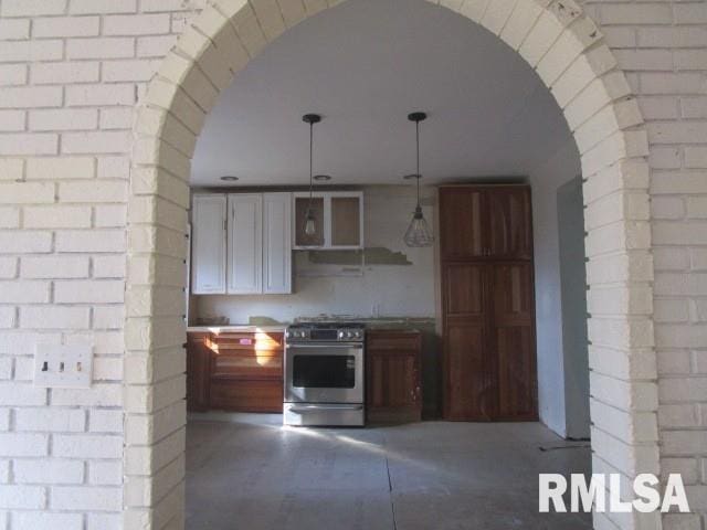 kitchen with arched walkways, white cabinets, decorative light fixtures, stainless steel range with gas cooktop, and open shelves