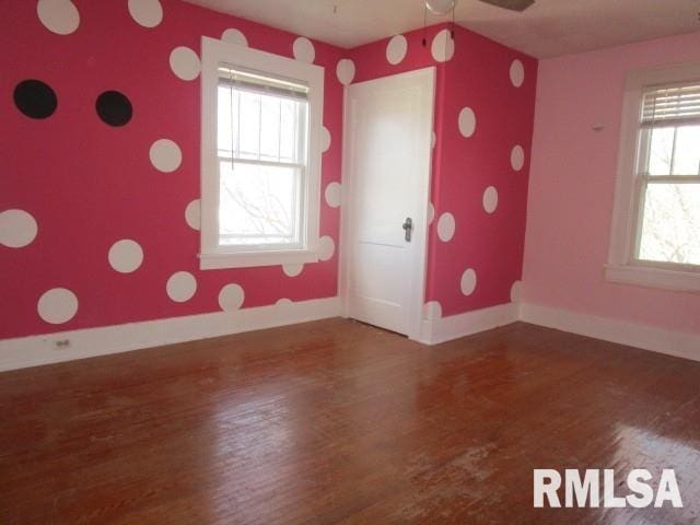 spare room featuring a ceiling fan, baseboards, and wood finished floors