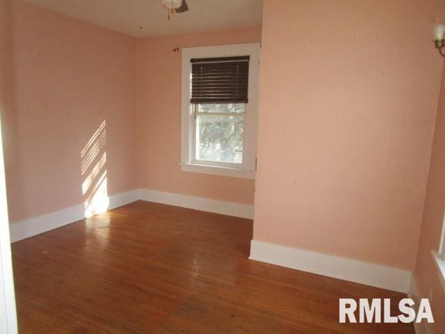 spare room featuring wood finished floors and baseboards