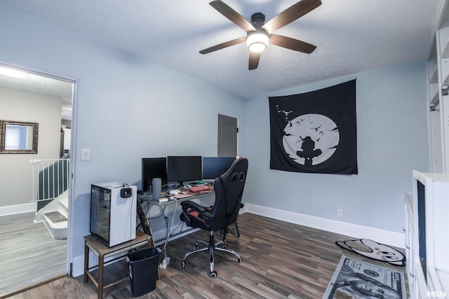 home office featuring ceiling fan, a textured ceiling, baseboards, and wood finished floors