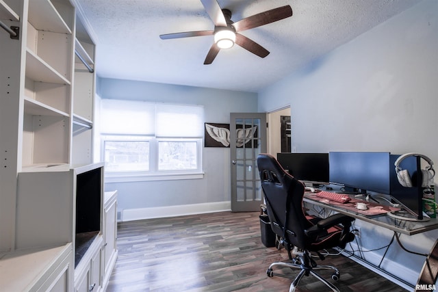 office space with a ceiling fan, a textured ceiling, baseboards, and wood finished floors