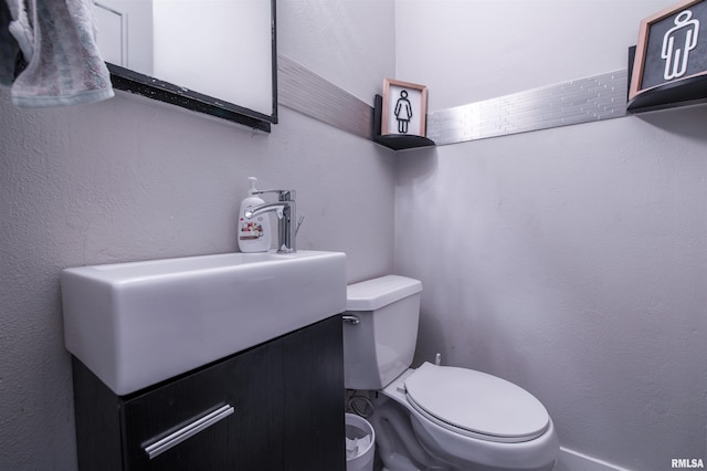 half bathroom featuring toilet and vanity