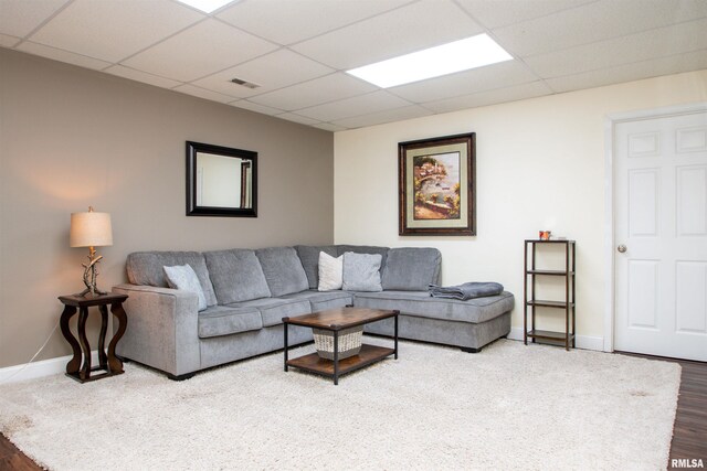 living area featuring a paneled ceiling, visible vents, baseboards, and wood finished floors