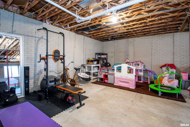 workout area featuring brick wall