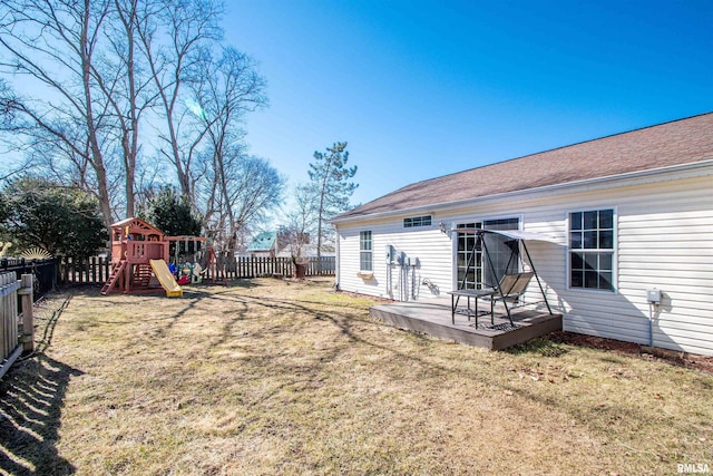 view of yard featuring a fenced backyard, a deck, and a playground