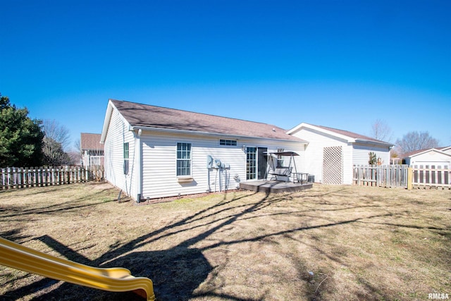 rear view of house with fence, a deck, and a lawn