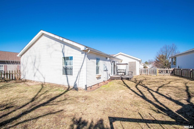 back of house with fence and a lawn