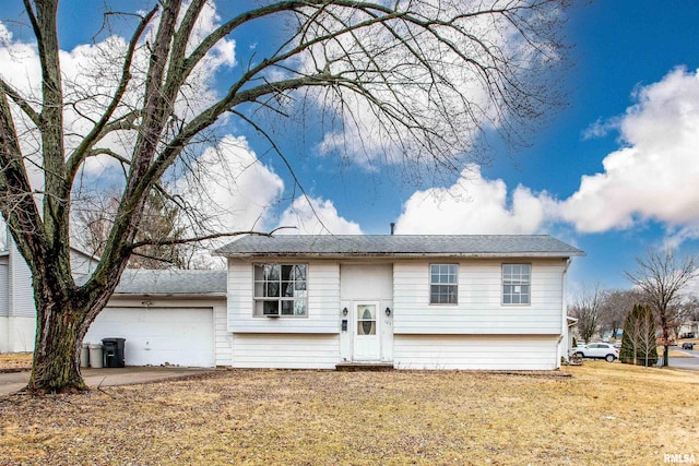 bi-level home with an attached garage and a front yard