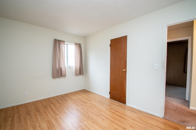 unfurnished room featuring light wood-type flooring and baseboards