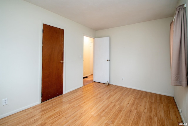 unfurnished bedroom featuring light wood finished floors and baseboards