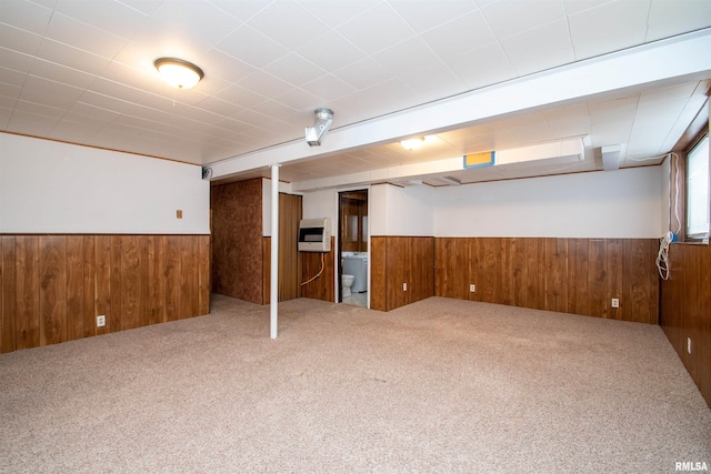 below grade area featuring carpet floors, a wainscoted wall, wooden walls, and heating unit