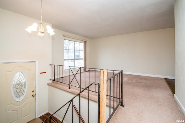 entryway featuring carpet flooring, baseboards, and an inviting chandelier