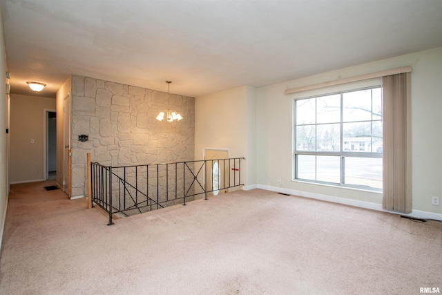 unfurnished room featuring baseboards, carpet floors, visible vents, and a notable chandelier