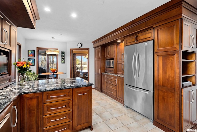 kitchen with brown cabinets, dark stone countertops, decorative light fixtures, stainless steel appliances, and light tile patterned flooring