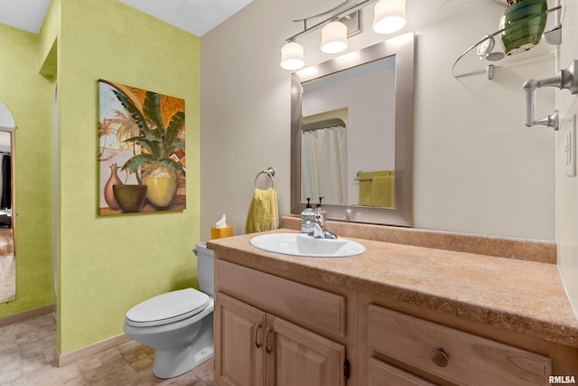 bathroom featuring vanity, toilet, and baseboards