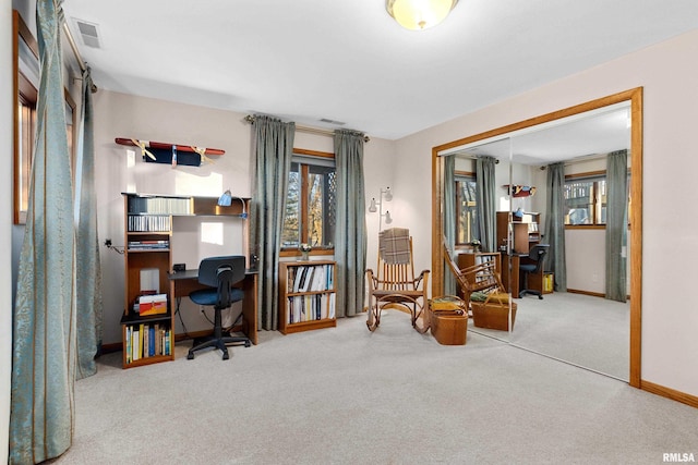 carpeted office space with visible vents and baseboards