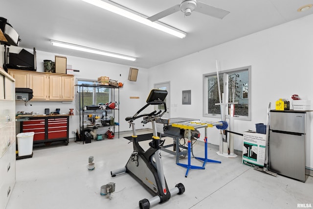 exercise room with a workshop area, electric panel, and a ceiling fan