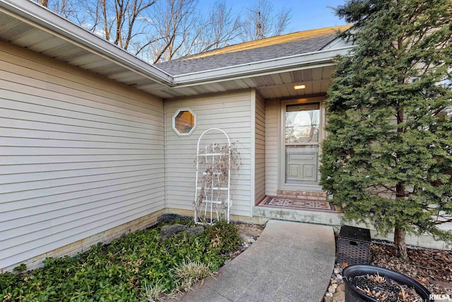 entrance to property featuring a shingled roof