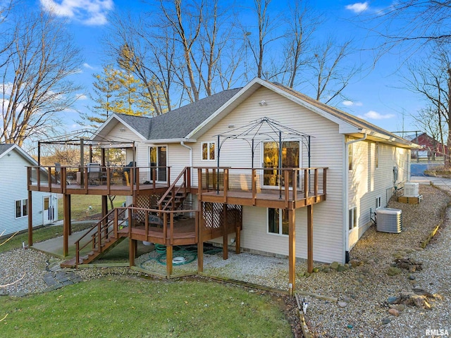 rear view of property featuring stairway, central AC unit, a lawn, and a deck