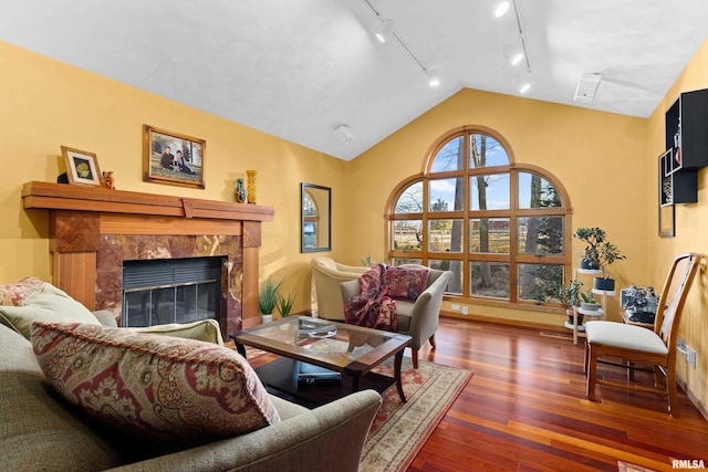 living area with lofted ceiling, wood finished floors, and a high end fireplace