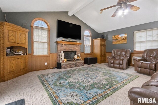 living room featuring a healthy amount of sunlight, vaulted ceiling with beams, light carpet, and wainscoting