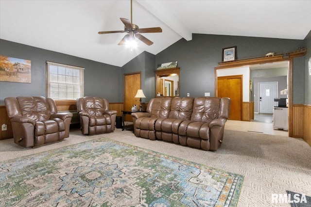 carpeted living area featuring a ceiling fan, wainscoting, lofted ceiling with beams, and wooden walls