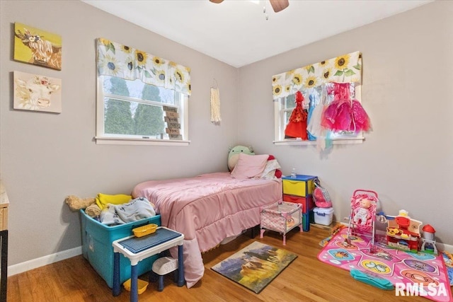 bedroom featuring ceiling fan, baseboards, and wood finished floors