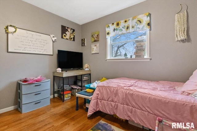 bedroom with light wood-style floors and baseboards