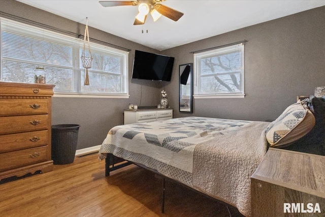 bedroom featuring light wood-style floors, baseboards, and a ceiling fan