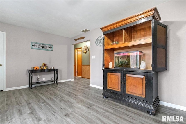 interior space with wood finished floors, visible vents, and baseboards