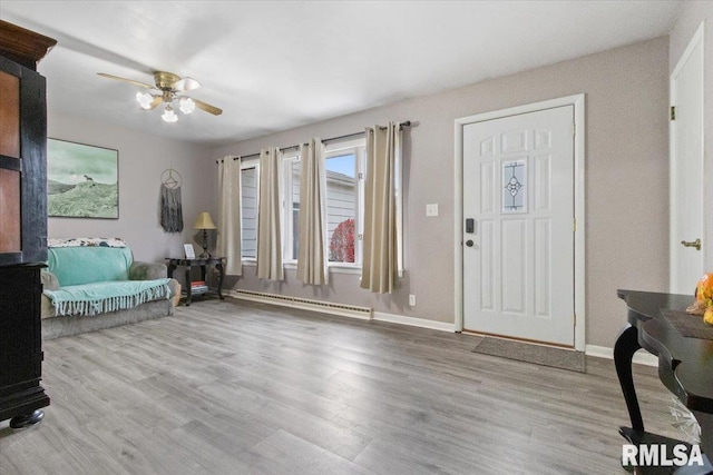 entryway featuring ceiling fan, baseboards, baseboard heating, and wood finished floors