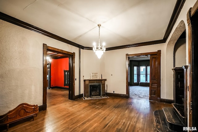 unfurnished living room featuring arched walkways, a fireplace, hardwood / wood-style floors, and ornamental molding