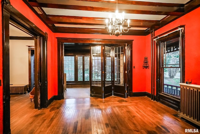 foyer entrance featuring french doors, wood-type flooring, beam ceiling, and radiator heating unit