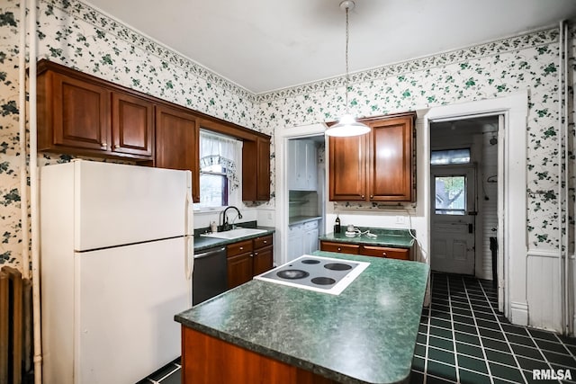 kitchen with dark countertops, a kitchen island, wallpapered walls, white appliances, and a sink