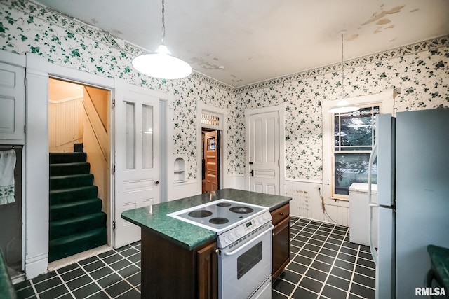 kitchen featuring wallpapered walls, white appliances, dark countertops, and a kitchen island