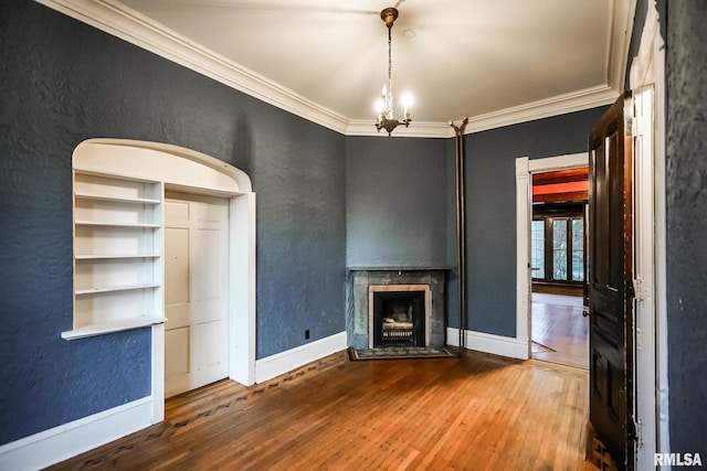 unfurnished living room featuring hardwood / wood-style flooring, a fireplace with flush hearth, baseboards, and ornamental molding