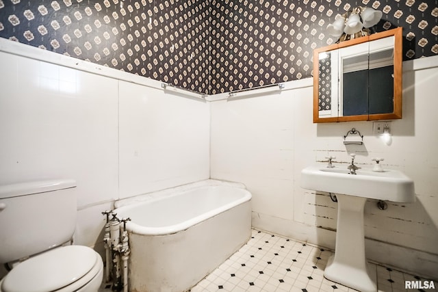 bathroom featuring wallpapered walls, tile patterned floors, toilet, and a tub