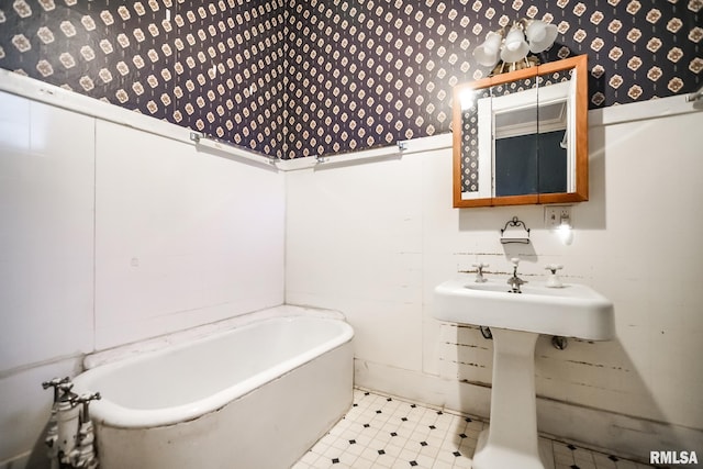 full bath with tile patterned floors, wallpapered walls, and a washtub